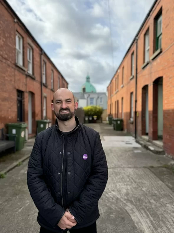 Eoin on the campaign trail, smiling at the camera in a classic mews laneway of south Dublin.